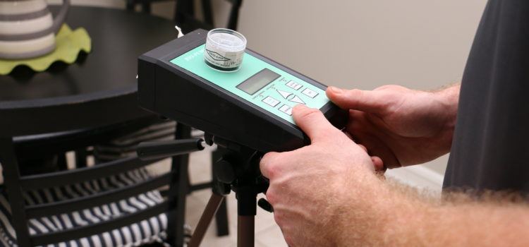 Inspector setting up an air sampling pump in a home